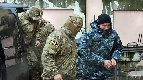 Nhân viên Cơ quan An ninh Liên bang Nga dẫn một thủy thủ Ukraine bị bắt cùng 3 tàu Ukraine ra tòa đầu tuần này. Ảnh: REUTERS
