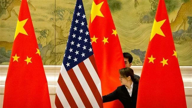 Chuẩn bị trưng bày cờ Mỹ và cờ Trung Quốc trước một phiên đàm phán thương mại giữa hai phái đoàn Mỹ và Trung Quốc tại Nhà khách Điếu Ngư Đài ở Bắc Kinh (Trung Quốc) ngày 14-2. Ảnh: AFP