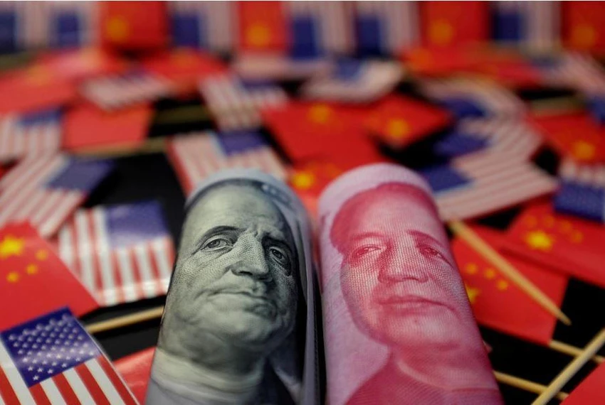 Đồng USD của Mỹ (trái) và đồng Nhân dân tệ của Trung Quốc (phải). Ảnh: REUTERS