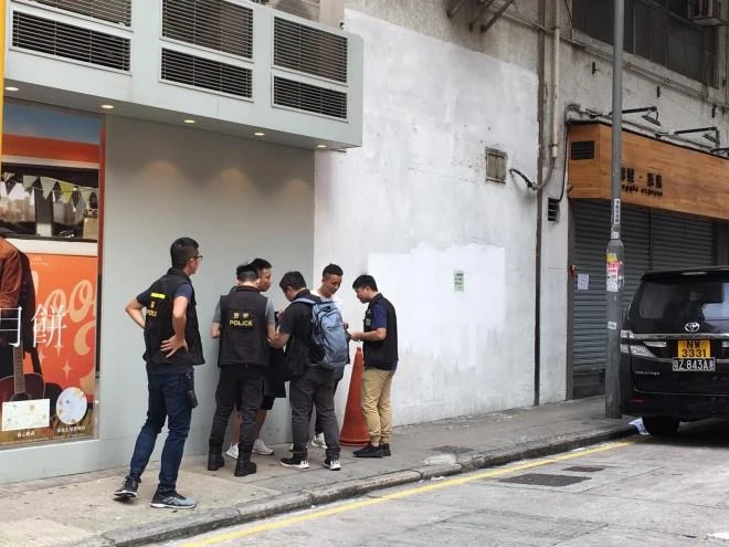 Cảnh sát tiếp cận kiểm tra giấy tờ tùy thân và tư trang thanh niên Hong Kong trên đường phố. Ảnh: SCMP