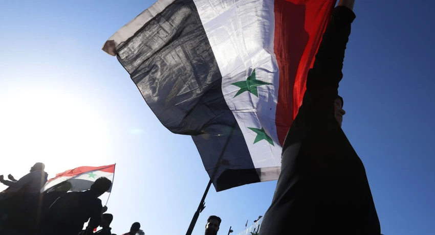 Người ủng hộ chính phủ Syria cầm cờ quốc gia Syria trong một cuộc biểu tình phản đối phương Tây, sau khi Mỹ-Anh-Pháp cùng không kích Syria với lý do nước này sử dụng vũ khí hóa học chống lại dân thường, tháng 4-2018. Ảnh: SPUTNIK