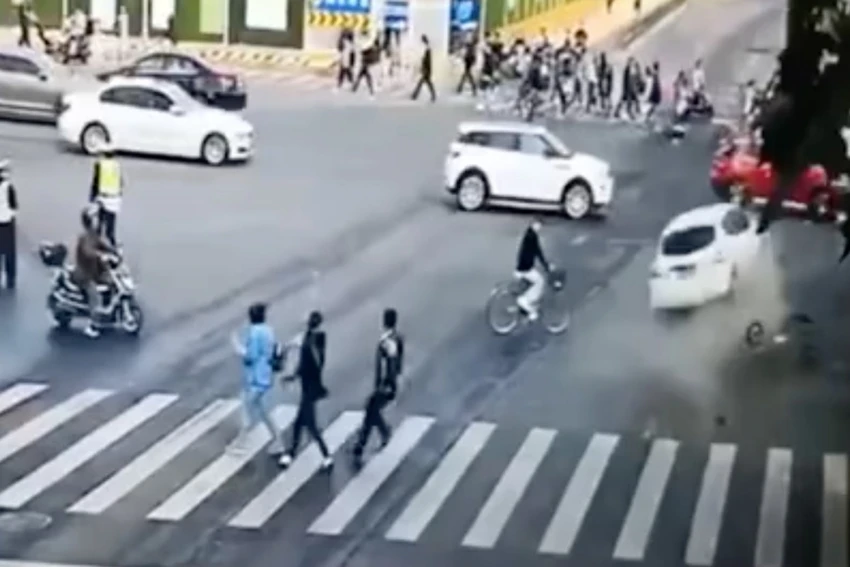 Từ hình ảnh từ máy quay giám sát an ninh có thể thấy một chiếc ô tô màu trắng được điều khiển vượt đèn đỏ và tông phải một phương tiện khác trong sự hốt hoảng của rất nhiều người đi đường. Ảnh: SCMP
