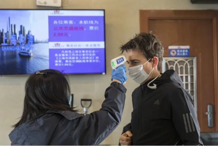 Kiểm tra nhiệt độ tại một bến phà chở khách ở Thượng Hải (Trung Quốc) ngày 30-1. Ảnh: BLOOMBERG