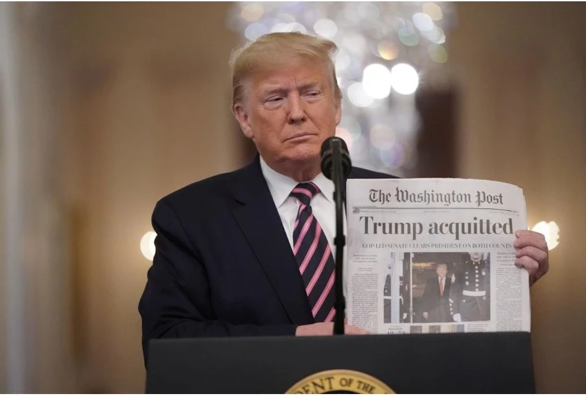 Tổng thống Mỹ Donald Trump cầm một tờ báo Washington Post đưa tin ông được Thượng viện tuyên trắng án, khi phát biểu tại Nhà Trắng ngày 6-2. Ảnh: REUTERS