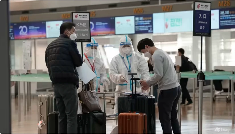 Nhân viên kiểm dịch hướng dẫn du khách tại sảnh khởi hành của sân bay quốc tế Incheon ở Incheon (Hàn Quốc) ngày 7-12. Ảnh AP