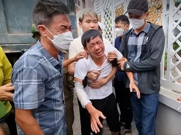 Anh Hùng khóc ngất khi cảnh sát đưa thi thể vợ con ra ngoài. Ảnh: NT Anh Hùng khóc ngất khi cảnh sát đưa thi thể vợ con ra ngoài. Ảnh: NT