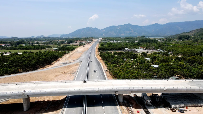 Người dân đứng xem xe cộ lưu thông trên một cầu vượt cao tốc.