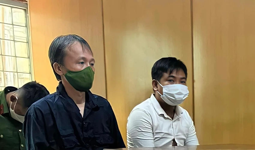 Bị cáo Trực (áo xanh) và Bình tại tòa sáng 28-7. Ảnh: H.YẾN