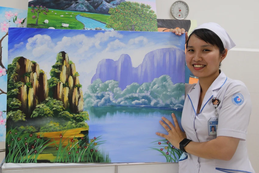 Nữ hộ sinh Trần Thị Mộng Tuyền và tác phẩm của chị . Ảnh: HOÀNG LAN Nữ hộ sinh Trần Thị Mộng Tuyền và tác phẩm của chị . Ảnh: HOÀNG LAN