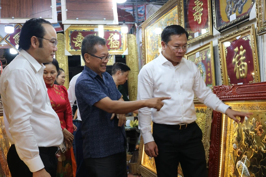 Ông Huỳnh Khắc Tiệp (phải), Bí thư Quận ủy quận 12 tham quan gian hàng tại phố.jpg