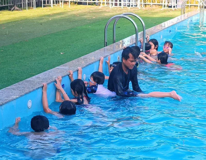 Học sinh lớp 1 đang được các giáo viên tập các kỹ năng bơi lội cơ bản. Ảnh: NÚI XANH Học sinh lớp 1 đang được các giáo viên tập các kỹ năng bơi lội cơ bản. Ảnh: NÚI XANH
