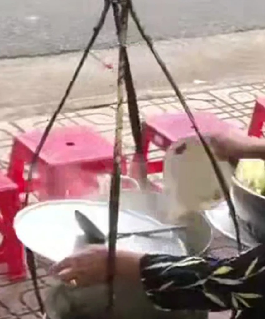 Hình ảnh được cho là người phụ nữ đổ tô nước thừa vào nồi nước lèo. (Ảnh cắt từ clip)