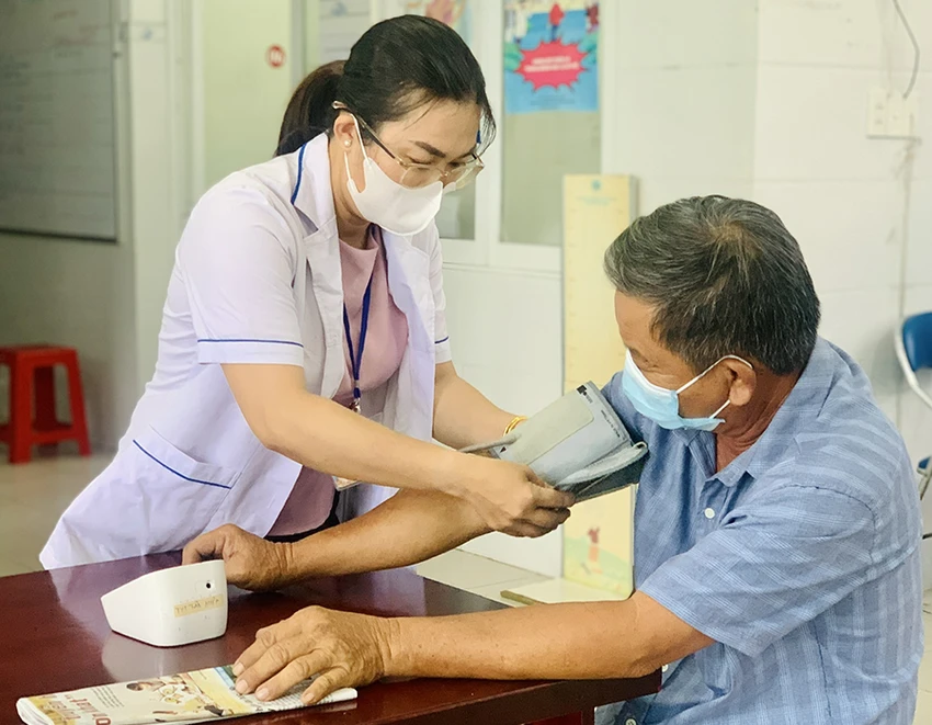 Nhân viên y tế cơ sở ở Trạm y tế xã Tân Hiệp, huyện Hóc Môn, TP.HCM khám chữa bệnh cho người dân. Ảnh: THẢO PHƯƠNG