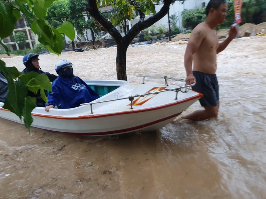 Nhiều người dân đã phải sử dụng ghe để qua đoạn nước nguy hiểm. Ảnh: QN ngap-nang-o-quy-nhon-binh-dinh