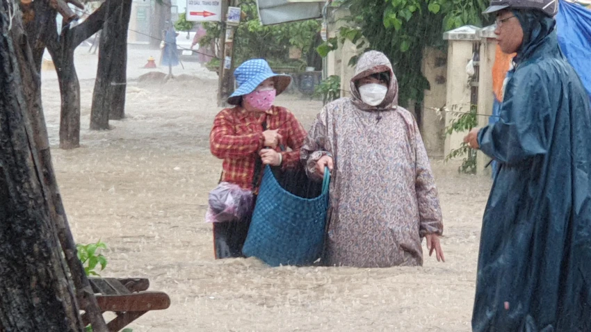 Người dân bì bõm trong nước để về nhà. Ảnh: QN ngap-nang-o-quy-nhon-binh-dinh