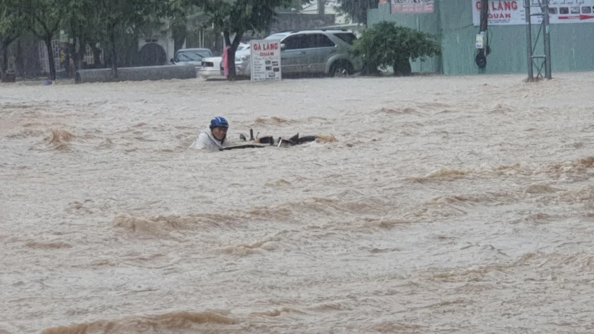 Nước chảy xiết cuốn trôi người và xe máy gần chục mét. Ảnh: QN ngap-nang-o-quy-nhon-binh-dinh