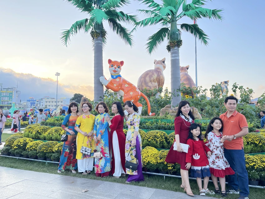 Nhiều gia đình chọn check-in với biểu tượng chú mèo trèo cây cau. Ảnh QN Nhiều gia đình chọn check-in với biểu tượng chú mèo trèo cây cau. Ảnh QN
