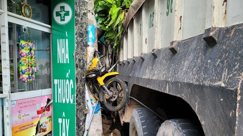 Một chiếc xe máy bị húc văng cao kẹt giữa xe ben và cột điện. Ảnh: LA Một chiếc xe máy bị húc văng cao kẹt giữa xe ben và cột điện. Ảnh: LA