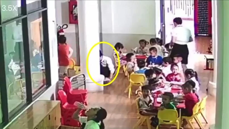 Bảo mẫu bốc lại cơm đổ cho bé trai tiếp tục ăn. Ảnh: Cắt từ camera Bảo mẫu bốc lại cơm đổ cho bé trai tiếp tục ăn. Ảnh: Cắt từ camera