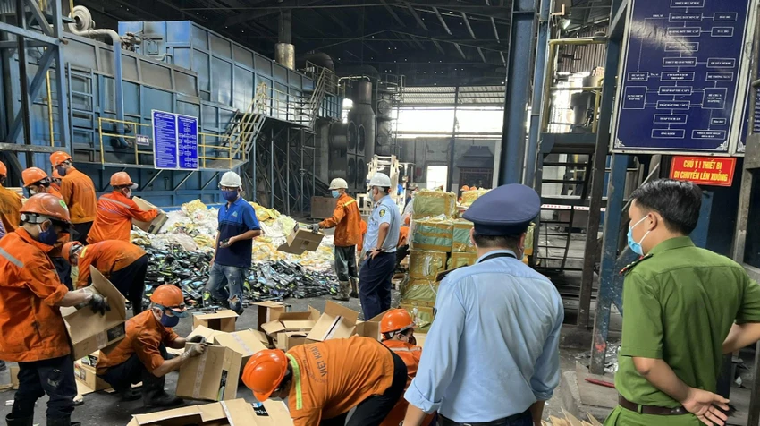 Cơ quan chức năng giám sát tiêu hủy số hàng hóa nhập lậu. Ảnh: QLTT