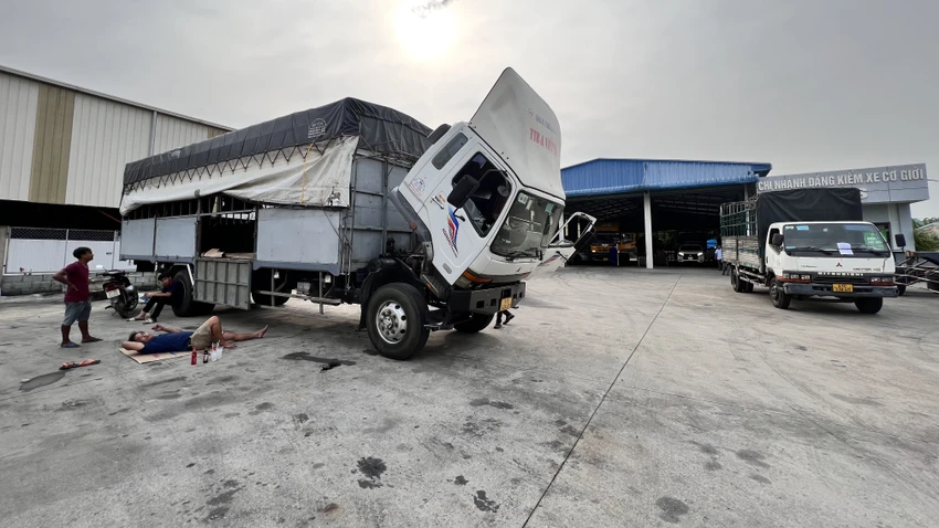 Tài xế trải chiếu nằm trong trong sân Trung tâm đăng kiểm xe cơ giới 61-03S. Ảnh: LÊ ÁNH Tài xế trải chiếu nằm trong trong sân Trung tâm đăng kiểm xe cơ giới 61-03S. Ảnh: LÊ ÁNH