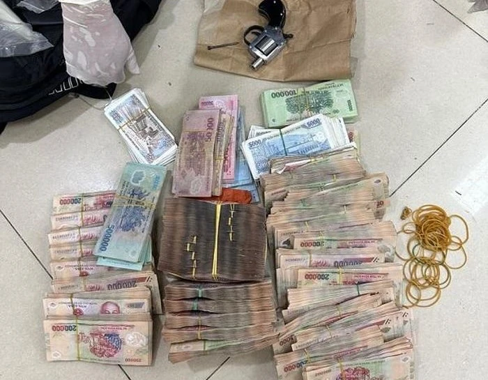 Số tiền khoảng 700 triệu đồng cùng khẩu súng được thu giữ tại hiện trường. Ảnh: NHCC Số tiền khoảng 700 triệu đồng cùng khẩu súng được thu giữ tại hiện trường