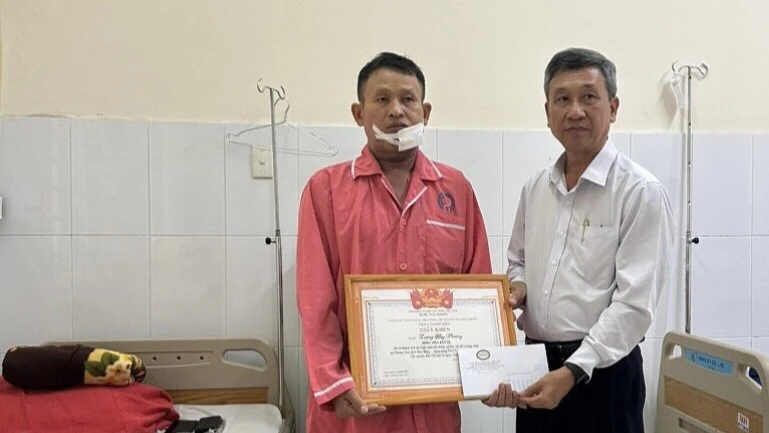 Ông Võ Đình Phong tặng giấy khen cho anh Phượng. Ảnh: LA Ông Võ Đình Phong tặng giấy khen cho anh Phượng