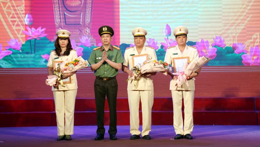 Giám đốc Công an tỉnh Bình Dương trao quyết định cho ba trưởng phòng nghiệp vụ phải sát nhập. Ảnh: LA