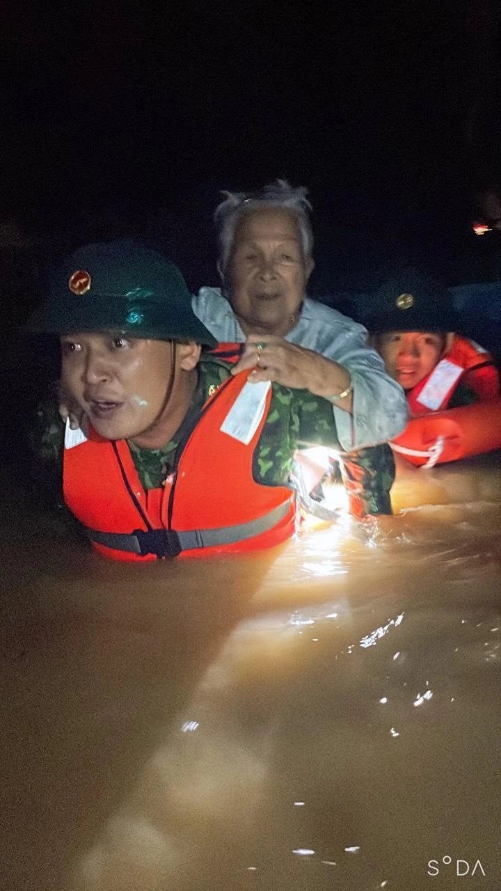 Lực lượng quân đội cõng cụ bà thoát khỏi dòng nước lũ. Lực lượng quân đội cõng cụ bà thoát khỏi dòng nước lũ.
