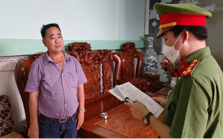 Công an tống đạt quyết định khởi tố Ngô Phú Cường. Ảnh: QUỲNH MINH