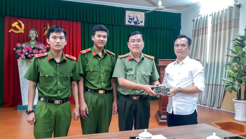 Lãnh đạo Công an TP Vĩnh Long cùng hai chiến sỹ trao trả tài sản cho người bị đánh rơi. Ảnh: CACC