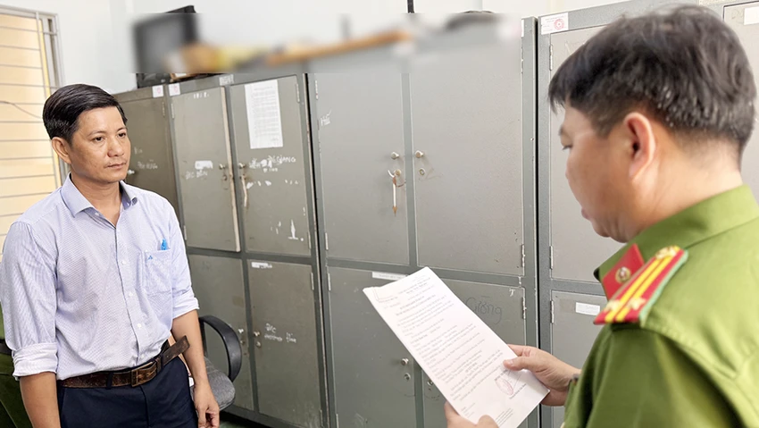 Công an tống đạt quyết định khởi tố bị can đối với Nguyễn Thanh Tùng. Ảnh: CACC