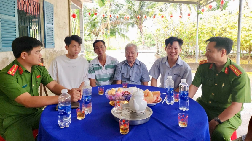 Cán bộ Công an xã Thạnh Hòa, TP Cần Thơ động viên gia đình hai anh em Đào Hoàng Ca và Đào Sơn Ca. Ảnh: Hải Dương