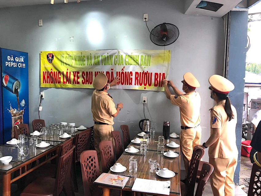 Đội CSGT Tân Sơn Nhất dán băng rôn tuyên truyền ngay khu vực bàn nhậu. Ảnh: MINH VƯƠNG Đội CSGT Tân Sơn Nhất dán băng rôn tuyên truyền ngay khu vực bàn nhậu. Ảnh: MINH VƯƠNG