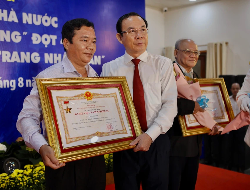 Bí thư Thành uỷ TP.HCM Nguyễn Văn Nên trao quyết định truy tặng danh hiệu "Bà Mẹ Việt Nam anh hùng" cho gia đình Mẹ Phan Thị Huệ. Ảnh: NGUYỆT NHI