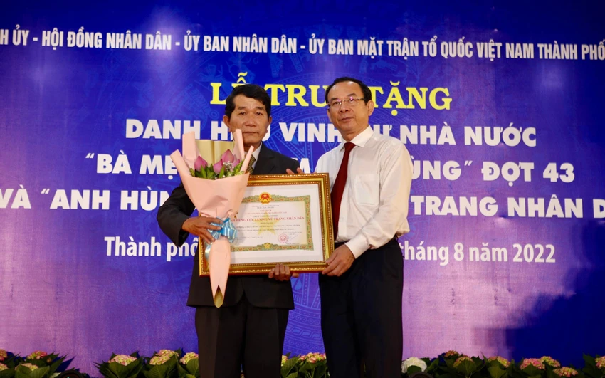 Bí thư Thành uỷ TP.HCM Nguyễn Văn Nên trao quyết định truy tặng danh hiệu "Anh hùng lực lượng vũ trang nhân dân" cho gia đình liệt sĩ Phan Văn Hân. Ảnh: NGUYỆT NHI