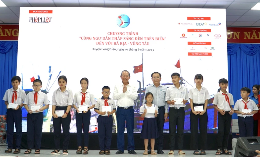 Nguyên Phó Thủ tướng Thường trực Trương Hoà Bình và Tổng Biên tập báo Pháp Luật TP.HCM trao học bổng cho học sinh có thành tích tốt. Ảnh: BẢO PHƯƠNG