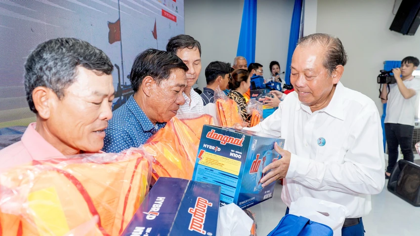 Nguyên Phó Thủ tướng Thường trực Chính phủ Trương Hoà Bình trao quà cho ngư dân. Ảnh: MẠNH THẮNG