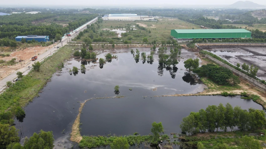 Một đoạn tường rào hồ chứa chất thải bị vỡ khiến nước tràn ra khu đất lân cận và suối Giao Kèo, hướng về đập Châu Pha-Ảnh:HS
