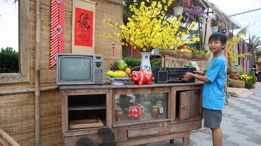 Bé trai thích thú với không gian trang trí trong nhà Tết xưa. Ảnh: TK Bé trai thích thú với không gian trang trí trong nhà Tết xưa. Ảnh: TK