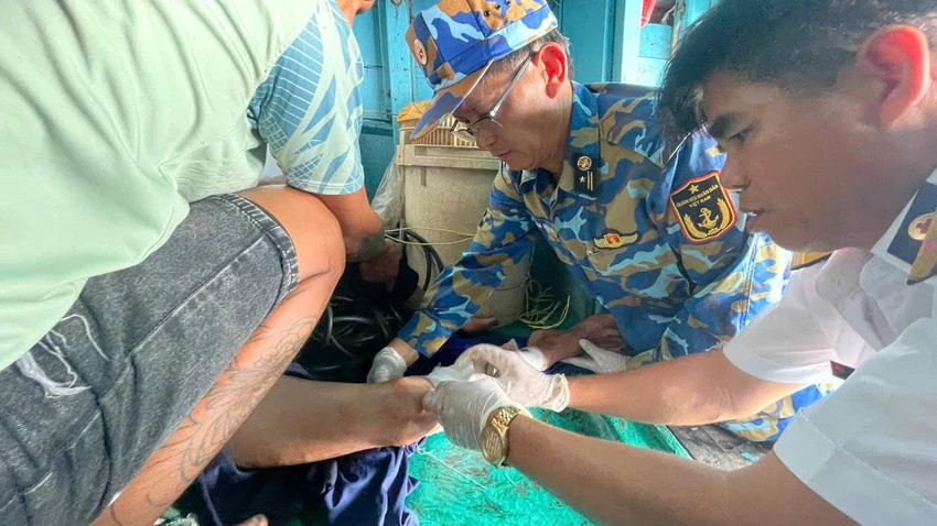 2. Quân Y nhà giàn tiếp cận và vệ sinh, băng bó gãy chân cho nạn nhân.jpg