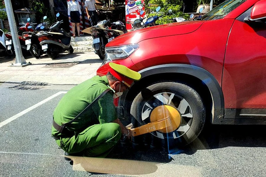 Công an TP Nha Trang đang khóa bánh xe một ô tô vi phạm đỗ xe trên đường Yersin vào ngày 11-6. Ảnh: HUỲNH HẢI Công an TP Nha Trang đang khóa bánh xe một ô tô vi phạm đỗ xe trên đường Yersin vào ngày 11-6. Ảnh: HUỲNH HẢI