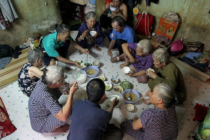 Bữa cơm chung của "đại gia đình" trước giờ đi bán vé số. Ảnh: HOÀNG GIANG