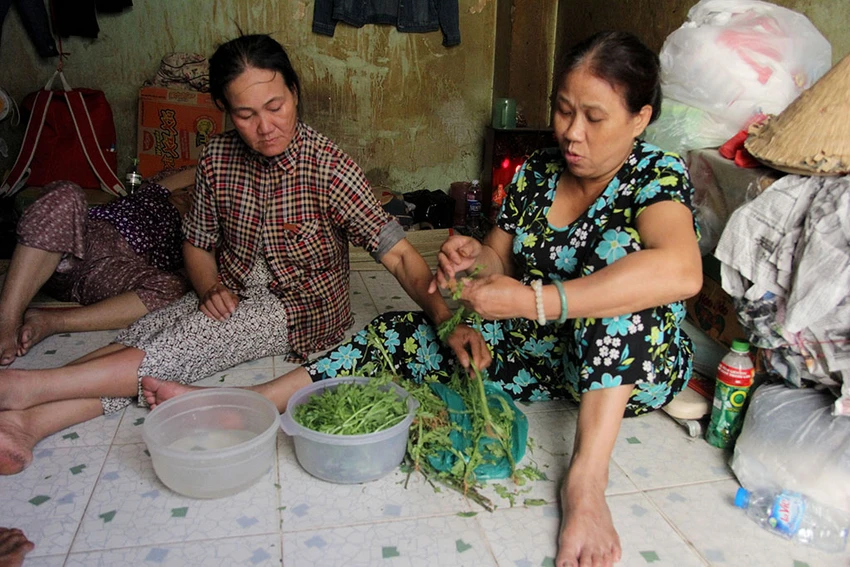 Chị Đào Thị Lê - vợ anh Tiến (bìa phải) đang chuẩn bị bữa cơm cho cả gia đình.