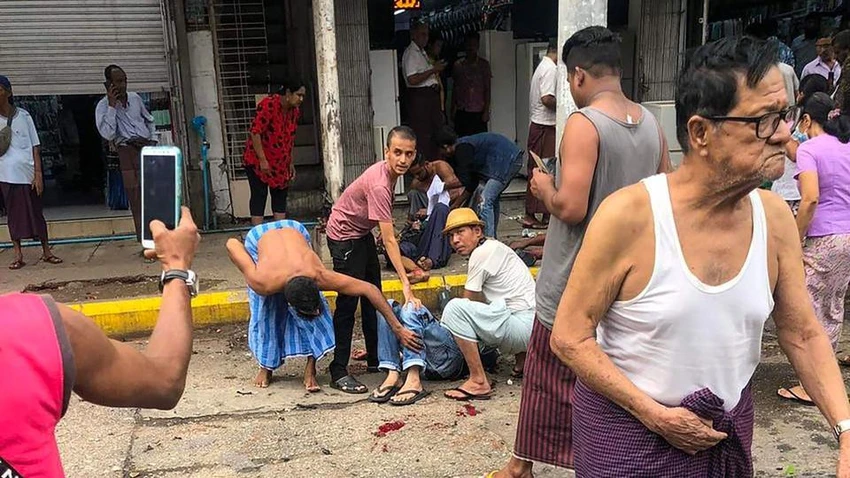 Những người qua đường đang giúp đỡ một người bị thương. Ảnh: AFP Những người qua đường đang giúp đỡ một người bị thương. Ảnh: AFP