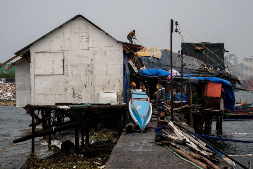 Người dân buộc mái nhà của mình trước khi siêu bão Noru đổ bộ ngày 25-9. Ảnh: REUTERS