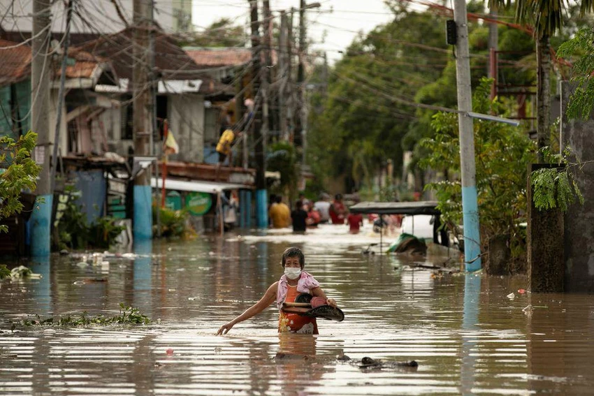 Người dân lội qua vùng nước ngập sâu do siêu bão Noru, ở huyện San Miguel, tỉnh Bulacan (Philippines) ngày 26-9. Ảnh: REUTERS