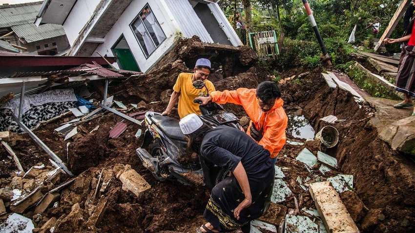Người dân đào bới đống đổ nát mong tìm lại được tài sản. Ảnh: AFP