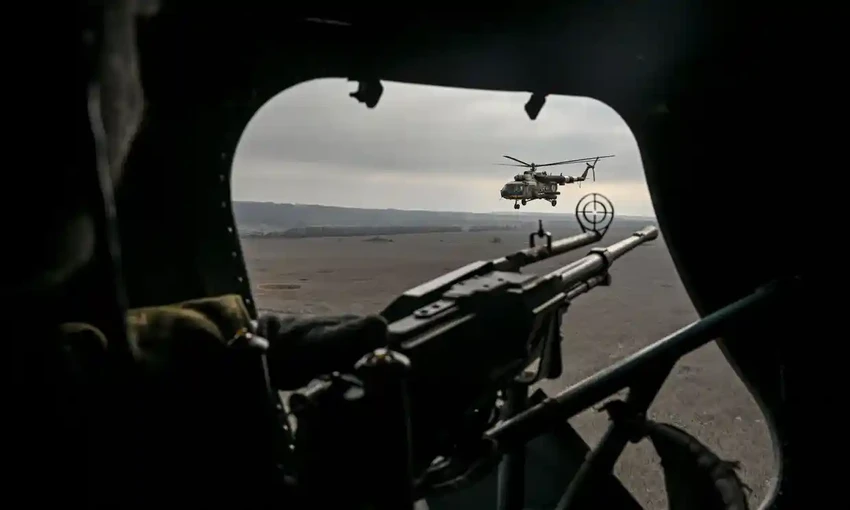 Xạ thủ Ukraine theo dõi một trực thăng bay qua mặt trận phía đông. Ảnh: AFP