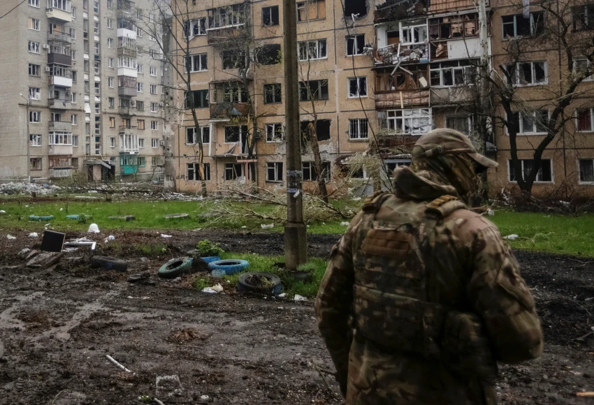 Binh sĩ Ukraine đứng trước các tòa nhà bị hư hại do pháo kích ở TP Bakhmut ngày 21-4. Ảnh: REUTERS Binh sĩ Ukraine đứng trước các tòa nhà bị hư hại do pháo kích ở TP Bakhmut ngày 21-4. Ảnh: REUTERS